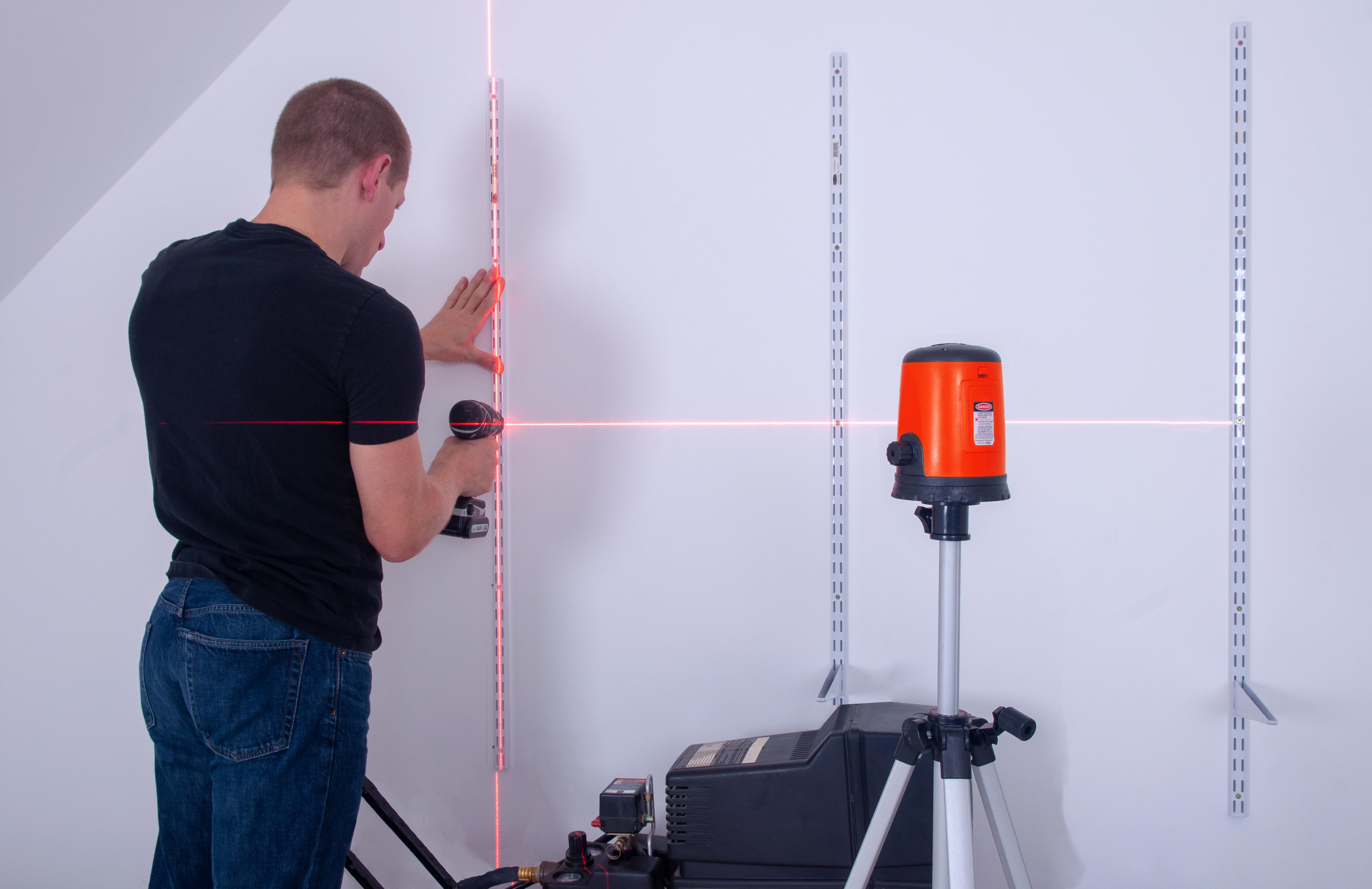 electrician placing a wall switch with Johnson Self-Leveling Ultra-Bright Cross-Line Laser Level Model: 40-6625